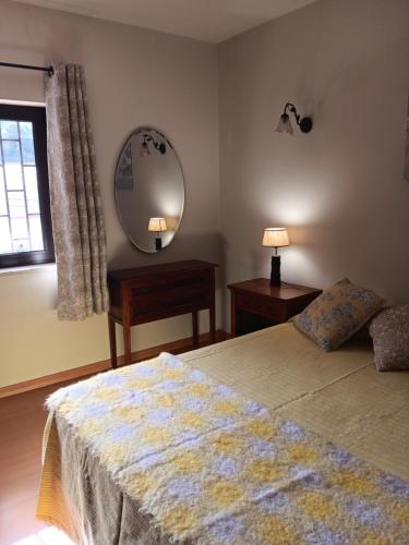 a bedroom with a bed and a mirror and a table at Apartamento Sintra in Sintra