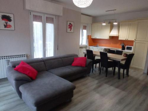 ein Wohnzimmer mit einem Sofa und einem Tisch mit Stühlen in der Unterkunft Casa Romolo in Garda