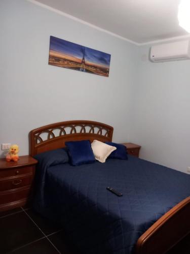 a bedroom with a bed with a blue comforter at AFFITTACAMERE DAL TRAMONTO ALL'ALBA in Montesano Scalo