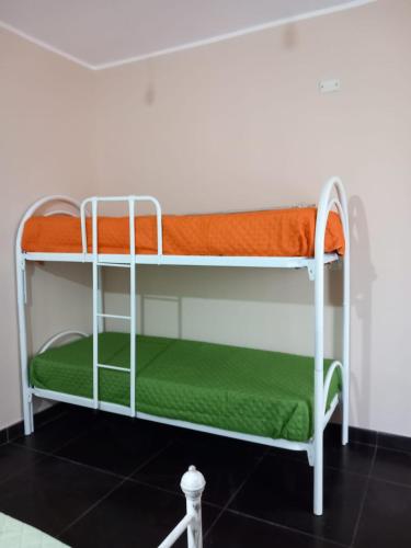 a bunk bed in a room with an orange pillow at AFFITTACAMERE DAL TRAMONTO ALL'ALBA in Montesano Scalo