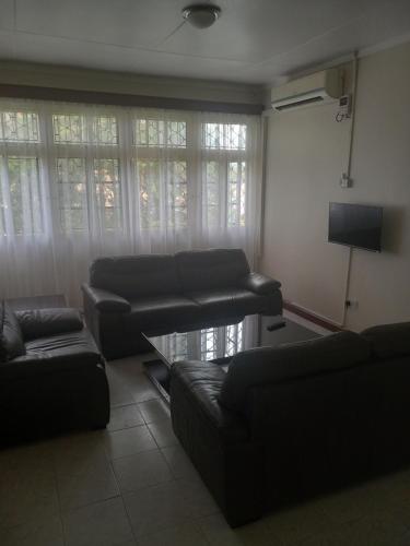 uma sala de estar com dois sofás e uma televisão em B&B HOTEL em Moshi