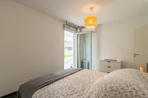 ein weißes Schlafzimmer mit einem Bett und einem Fenster in der Unterkunft Appartement 70 m2 climatisé avec balcon et parking in Marseille