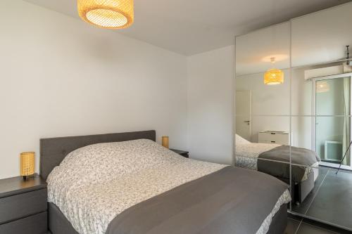- une chambre avec 2 lits aux murs blancs dans l'établissement Appartement 70 m2 climatisé avec balcon et parking, à Marseille