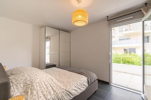 une chambre avec un lit et une grande fenêtre dans l'établissement Appartement 70 m2 climatisé avec balcon et parking, à Marseille