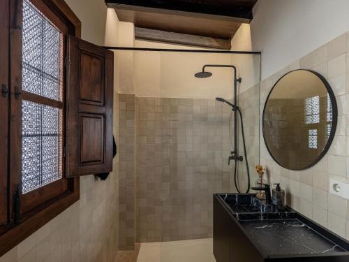 een badkamer met een wastafel, een douche en een spiegel bij Carmen de Azahar in Granada
