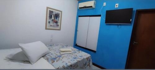 a small bedroom with a bed and a blue wall at HOTEL Al ATLANTICO in Aracaju