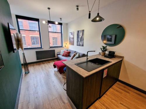 a living room with a kitchen and a living room with a couch at Stunning Northern Quarter Flat in Manchester