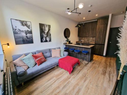 a living room with a couch and a kitchen at Stunning Northern Quarter Flat in Manchester