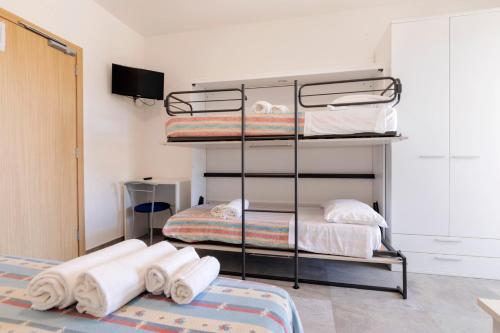 a bedroom with two bunk beds and towels at Camping Villaggio Il Frutteto in Cupra Marittima