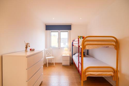 1 dormitorio con 2 literas y escritorio en Alojamento Encantador no Centro de Ponta Delgada, en Ponta Delgada