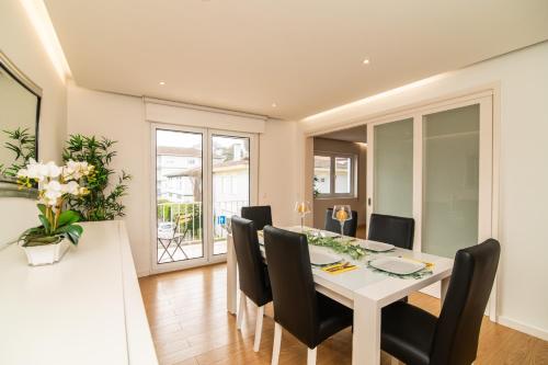 a dining room with a white table and black chairs at Alojamento Encantador no Centro de Ponta Delgada in Ponta Delgada