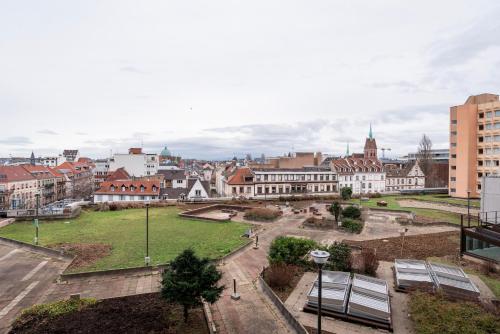 Blick auf eine Stadt mit Bänken und Gebäuden in der Unterkunft Le 4K - Vue dégagée, Clim, Gare 10min à pied in Straßburg