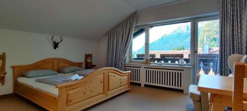 een slaapkamer met een houten bed en een groot raam bij Fewo Wetterstein in Garmisch-Partenkirchen