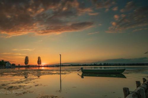 a boat sitting in the water at sunset at Gemütliches Haus mit Seeblick in Ermatingen