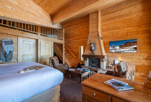 a bedroom with a bed and a desk and a fireplace at Hôtel Au Chamois d'Or by Les Etincelles in L'Alpe-d'Huez