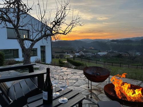 a table with a fire grill and a bottle of wine at De la Osa Hotel in Abres