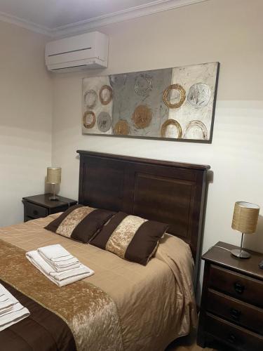 a bedroom with a bed and a painting on the wall at Cantinho da Estrela in Seia
