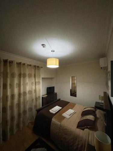a bedroom with a large bed and a light at Cantinho da Estrela in Seia