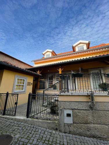 a house with a balcony and a fence at Cantinho da Estrela in Seia