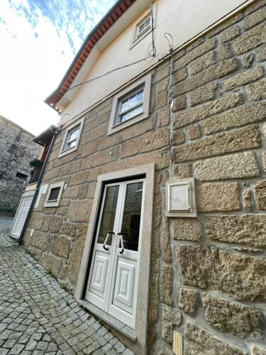 a stone building with a white door on it at Cantinho da Estrela in Seia