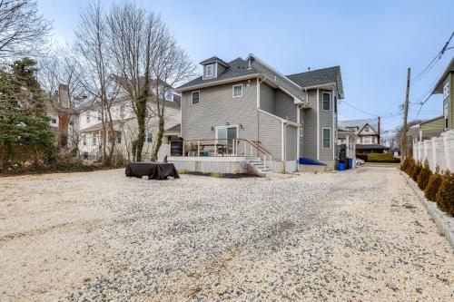 a house with a cow laying in the middle of a gravel driveway at Long Branch Getaway - Walk to Beaches and Dining! in Long Branch