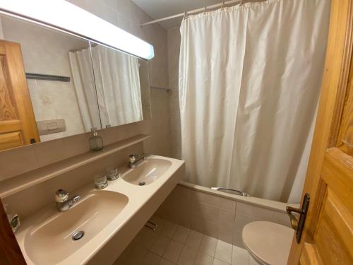 La salle de bains est pourvue d'un lavabo et d'un rideau de douche. dans l'établissement Apartment Corfou, à Crans-Montana
