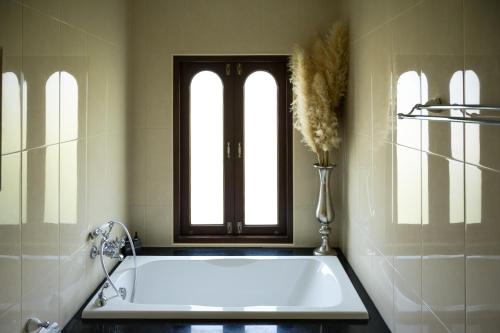 uma banheira na casa de banho com 2 janelas em Miranda's House Khaokho มิรันดาเฮ้าส์ เขาค้อ em Ban Lao Kok Kho