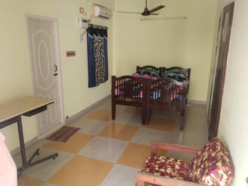 een kamer met een wieg en een stoel in een kamer bij Kamachi Residency in Chidambaram