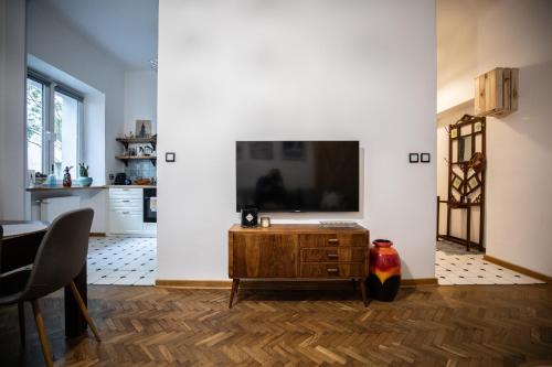 Apartament Miedziana City Center في وارسو: غرفة معيشة مع تلفزيون بشاشة مسطحة على جدار