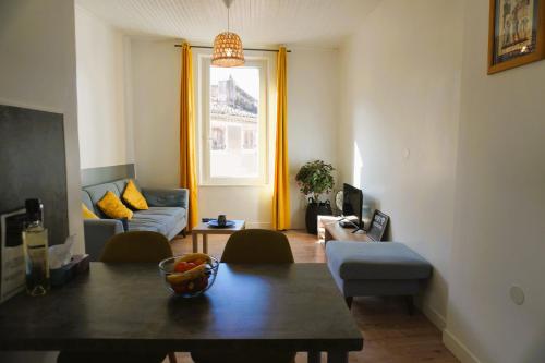 ein Wohnzimmer mit einem Sofa und einem Tisch in der Unterkunft Family' appart Narbonne Centre-ville Clim Wi-fi 2 chambres in Narbonne