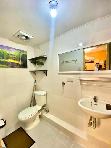 Baño blanco con aseo y lavamanos en Minimalist Condo One Spatial Iloilo 2 Bedroom Unit en Iloílo