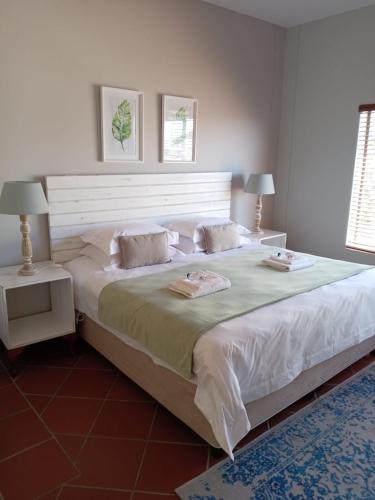 a large white bed with two pillows on it at LêPlek Guesthouse in Saldanha