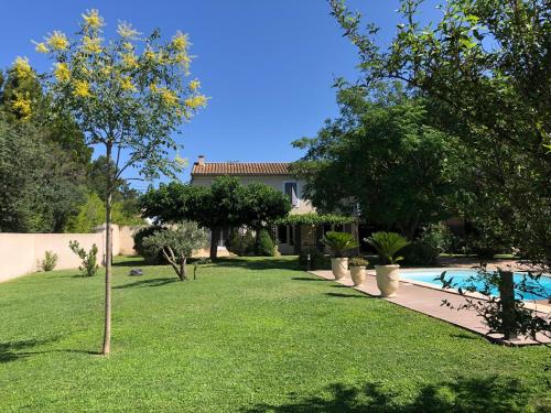 une maison avec une cour et une piscine dans l'établissement Petite Maison en Provence, à Arles