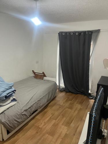 ein Schlafzimmer mit einem Bett und einem schwarzen Vorhang in der Unterkunft Sweet dream in London