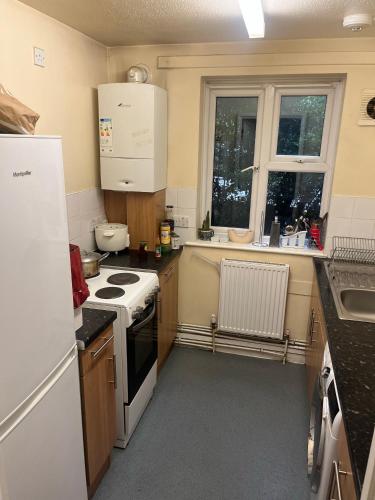 a small kitchen with a stove and a refrigerator at Sweet dream in London