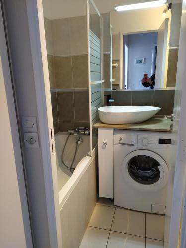 a bathroom with a sink and a washing machine at appart 6 pers vue mer classé 3* in Saint-Raphaël