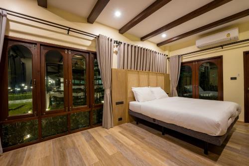 a bedroom with a bed and some windows at Miranda's House Khaokho มิรันดาเฮ้าส์ เขาค้อ in Ban Lao Kok Kho