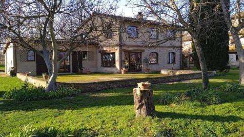 a house with a tree stump in front of it at CASALE SUL CLITUNNO in Foligno