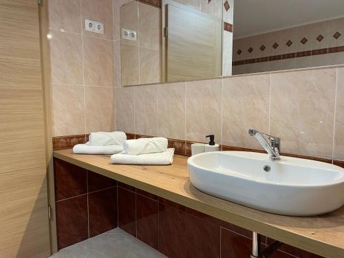 y baño con lavabo blanco y espejo. en All Seasons Apartments Laško en Laško