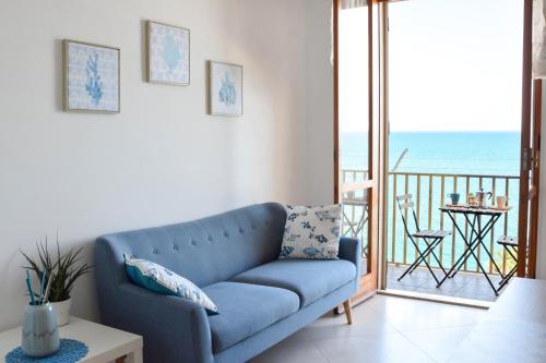 a blue couch in a living room with a view of the ocean at STELLA MARINA VACATION in Pozzallo