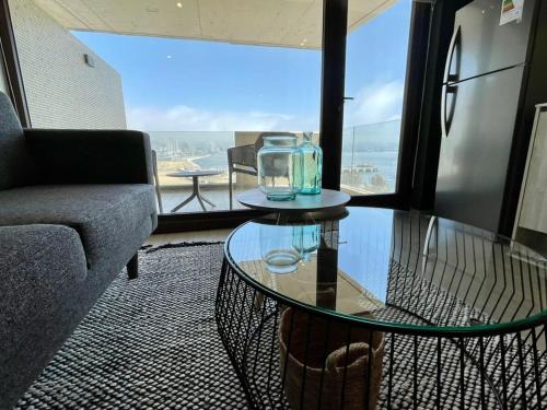 uma sala de estar com uma mesa de vidro e um sofá em HOM I TOP1 NUEVO STUDIO en mejor zona Valparaíso Parking em Valparaíso
