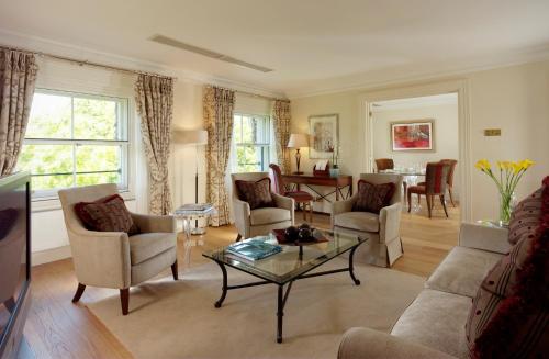 uma sala de estar com um sofá, cadeiras e uma mesa em Cheval Hyde Park Gate em Londres
