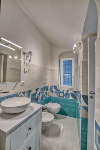 a bathroom with two toilets and a sink and a mirror at La dimora di Lunatiello in Atrani