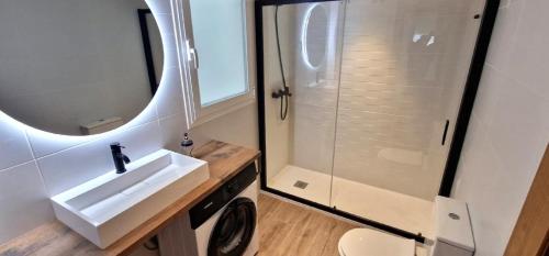 a bathroom with a shower and a sink and a washing machine at Plaza santa Ana in Benidorm