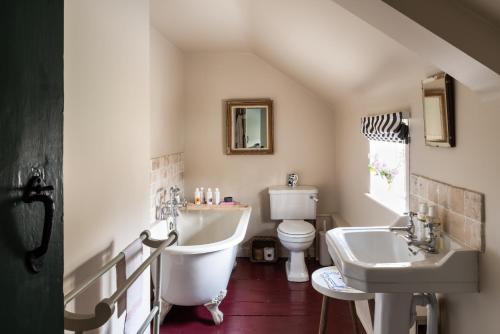 a bathroom with a sink and a tub and a toilet at Apple Cottage - Vivre Retreats in Wimborne Minster