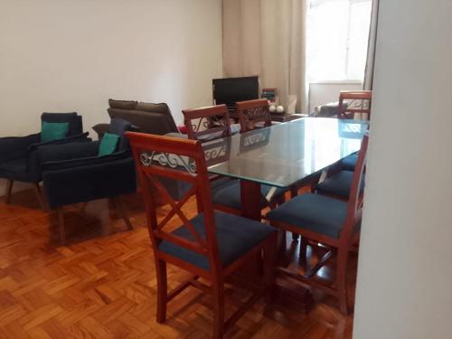 uma sala de jantar com uma mesa de vidro e cadeiras em HOSTEL e POUSADA SALVADOR PRAIA em Salvador