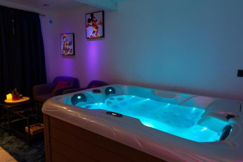 - une baignoire bleue dans une chambre avec un canapé dans l'établissement Suite Romantique - Centre historique, Jacuzzi, wifi, 10min gare, à Montpellier