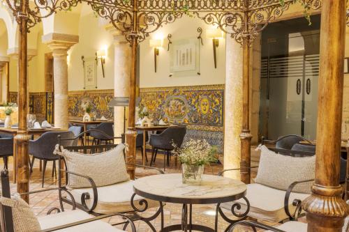 a room with tables and chairs and a wall with a mural at Hotel Ilunion Mérida Palace in Merida
