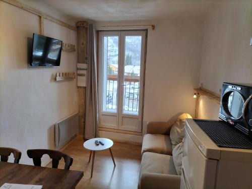 un salon avec un canapé et une table dans l'établissement A découvrir joli petit Appart au coeur du village, à Vallouise