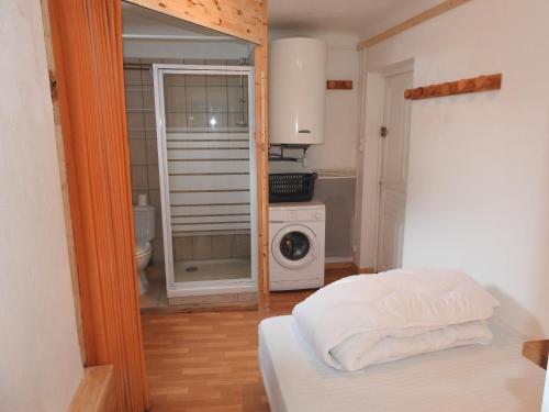 a bedroom with a bed and a washing machine at A découvrir joli petit Appart au coeur du village in Vallouise